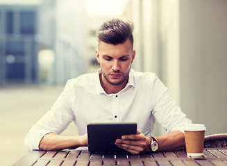 Image showing man with tablet pc and coffee at city cafe