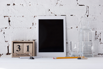 Image showing Mock up empty black tablet screen on the brick wall background