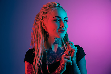 Image showing Caucasian young woman\'s portrait on gradient background in neon light