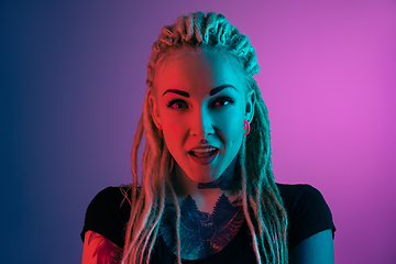 Image showing Caucasian young woman\'s portrait on gradient background in neon light