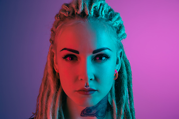 Image showing Caucasian young woman\'s portrait on gradient background in neon light