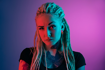 Image showing Caucasian young woman\'s portrait on gradient background in neon light