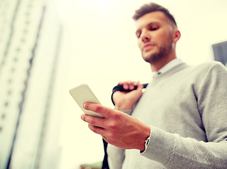 Image showing close up of man texting on smartphone in city