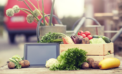 Image showing close up of vegetables with tablet pc on farm