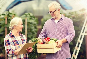 Image showing senior couple with box of vegetables on farm