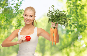 Image showing happy smiling young woman with heart and carrots