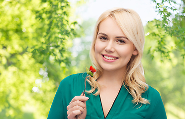 Image showing smiling young woman eating vegetables with fork