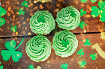 Image showing green cupcakes and shamrock on wooden table