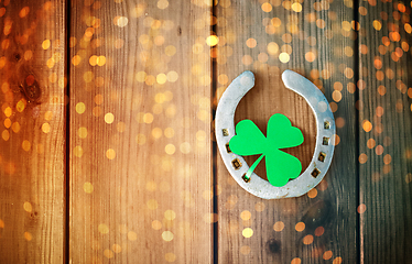 Image showing horseshoe with shamrock on wooden background