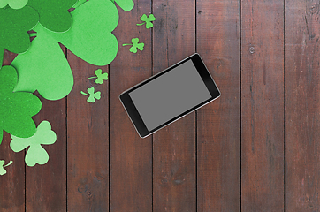 Image showing tablet pc and st patricks day decorations on wood