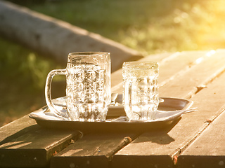 Image showing Glass jugs empty in the sunset