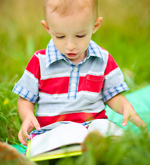 Image showing Little boy is reading book