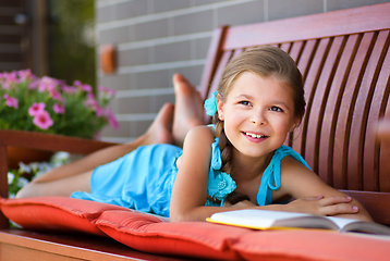 Image showing Little girl is reading a book