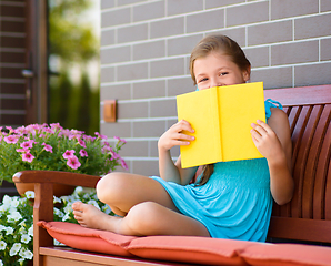 Image showing Little girl is reading a book