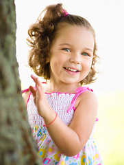 Image showing Cute little girl is playing hide and seek