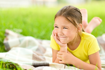 Image showing Portrait of a little girl laying on green grass