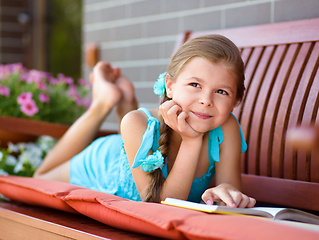 Image showing Little girl is reading a book