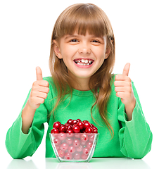 Image showing Cute girl is eating cherries