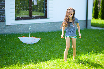 Image showing Happy girl is playing under rain