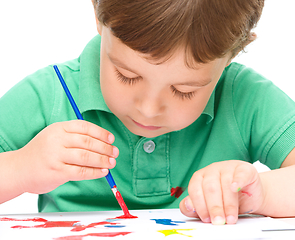 Image showing Little boy is playing with paints