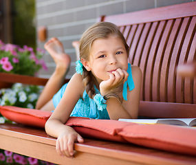 Image showing Little girl is reading a book