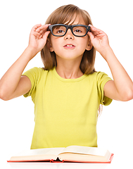 Image showing Little girl is reading a book