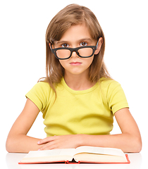 Image showing Little girl is reading a book