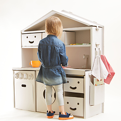 Image showing toddler girl playing with toy kitchen at home