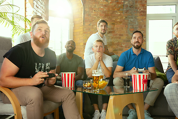 Image showing Group of excited friends playing video games at home