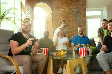 Image showing Group of excited friends playing video games at home