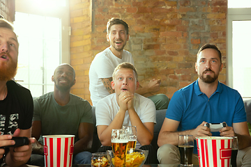 Image showing Group of excited friends playing video games at home