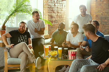 Image showing Group of excited friends playing video games at home