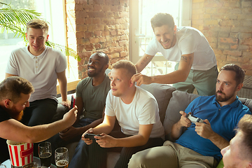 Image showing Group of excited friends playing video games at home