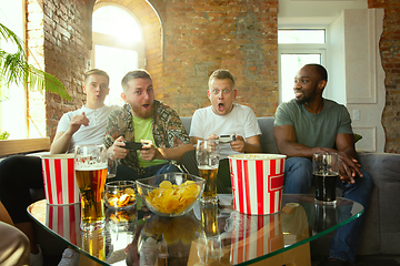 Image showing Group of excited friends playing video games at home