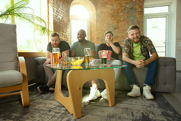 Image showing Group of friends watching football or soccer game on TV at home