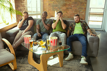 Image showing Group of friends watching football or soccer game on TV at home