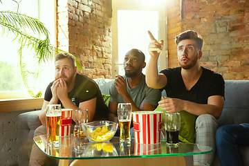 Image showing Group of friends watching football or soccer game on TV at home