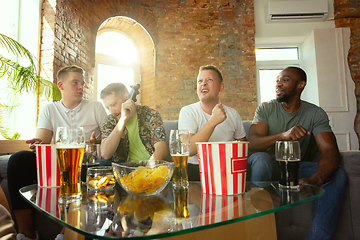 Image showing Group of excited friends playing video games at home