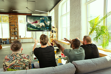 Image showing Group of friends watching football or soccer game on TV at home