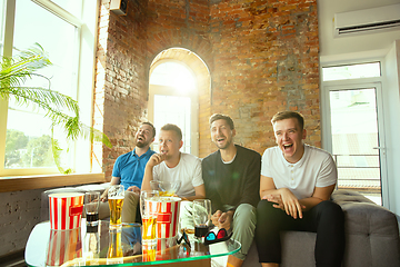 Image showing Group of friends watching football or soccer game on TV at home