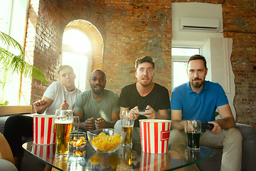 Image showing Group of excited friends playing video games at home