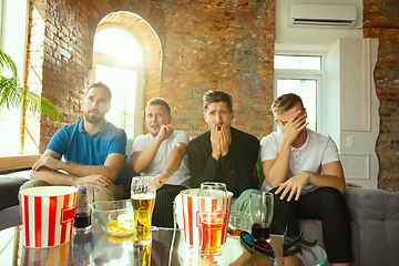 Image showing Group of friends watching football or soccer game on TV at home