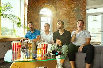 Image showing Group of friends watching football or soccer game on TV at home