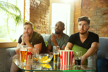 Image showing Group of friends watching football or soccer game on TV at home