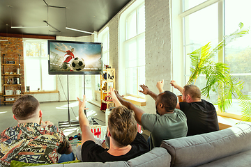 Image showing Group of friends watching football or soccer game on TV at home