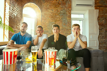 Image showing Group of friends watching football or soccer game on TV at home