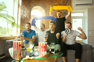 Image showing Group of friends watching football or soccer game on TV at home