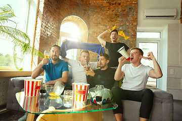 Image showing Group of friends watching football or soccer game on TV at home