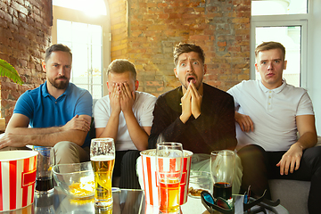 Image showing Group of friends watching football or soccer game on TV at home