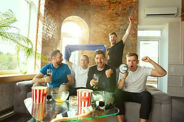 Image showing Group of friends watching football or soccer game on TV at home